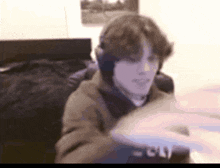 a young man wearing headphones is sitting in a chair in front of a computer .
