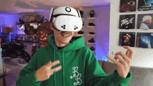 a man wearing a virtual reality headset and a green hoodie with the word true on it