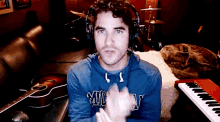 a man wearing headphones and a blue shirt that says mickey