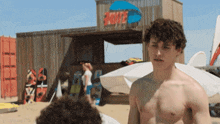 a man without a shirt stands in front of a building that says wake