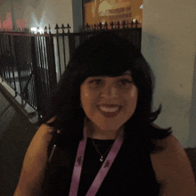 a woman smiles in front of a sign that says ' world of illusions '