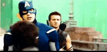 a man in a captain america costume is standing next to another man