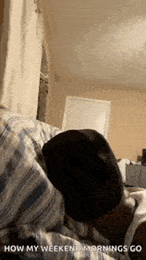 a man is laying on a bed with his head on a pillow in a bedroom .