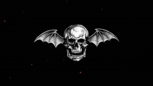 a skull with bat wings is surrounded by orange lights on a black background