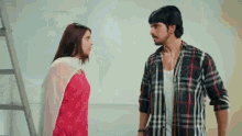 a man and a woman are standing next to each other and looking at each other in a room .