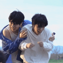 a man is carrying another man on his back while laughing .