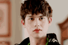 a close up of a young man 's face with dia written on the bottom right
