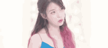 a woman with pink and black hair is wearing a blue dress .