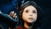 a little girl in a red dress is looking up at a person 's hand .