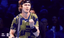 a tennis player is holding a tennis racquet in front of a scoreboard that says ad on it