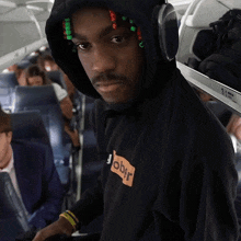 a man wearing headphones and a black hoodie that says ober