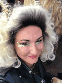 a woman wearing a wig and a leather jacket smiles