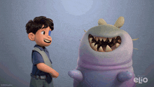 a boy standing next to a monster with the word elio on it