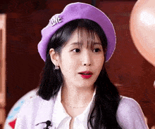 a woman is wearing a purple hat with the word love on it