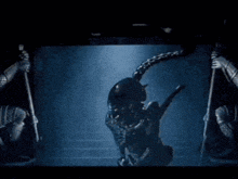 a group of people are standing in front of an alien