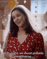 a woman wearing a veil and a red dress says " in hindsight we should probably stop making "