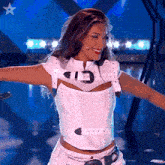 a woman wearing a white top with the number 13 on the front