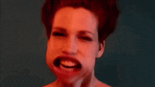 a woman with red hair is making a funny face and smiling .