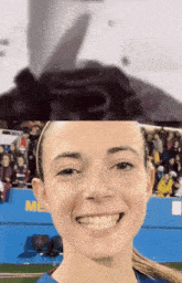 a woman is smiling in front of a blue wall that says me on it