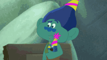 a troll wearing a party hat and holding a toy