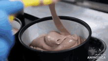 a person is pouring chocolate into a bowl that says made in animonica