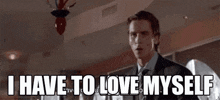 a man in a suit and tie is standing in a room and saying `` i have to love myself '' .