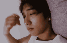 a man laying on a bed with his eyes closed