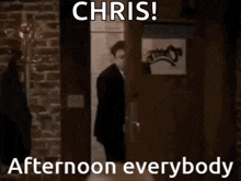 a man in a suit and tie is standing in a doorway with the words chris afternoon everybody below him