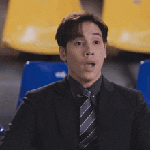 a man in a suit and tie is sitting in a chair