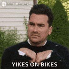 a man in a black sweater is making a funny face and saying `` yikes on bikes ''