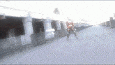 a man in a superhero costume is walking down a street under a bridge