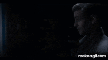 a man and a woman are standing next to each other in a dark room .