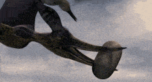 a dinosaur is holding an egg in its mouth while flying through a cloudy sky