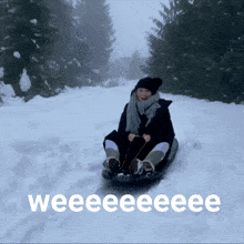 a woman is sledding down a snowy hill with the words weeeeeeeee written on the bottom