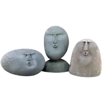 three rocks with faces carved into them are sitting next to each other