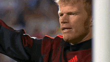 a man wearing a red and black adidas shirt