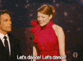 a woman in a red dress is dancing with a man in a suit and tie