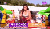 a woman is dancing in front of a sign that says 761 100 600 on it