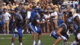 a football game is being played in front of a crowd with accon written on the bottom of the screen