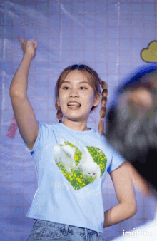 a girl wearing a blue shirt with a heart and two rabbits on it