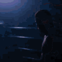 a man without a shirt stands in a dark room