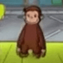 a close up of a stuffed monkey standing on a green surface .