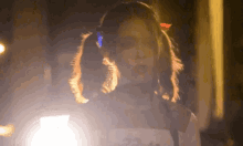 a girl with pigtails is wearing headphones and looking at the camera at night .