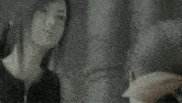 a black and white photo of a woman looking at herself in the mirror