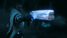 a man is holding a gun that is glowing blue