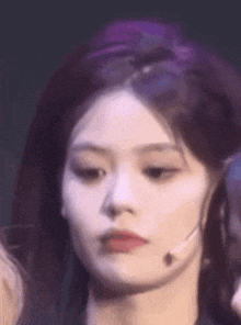 a close up of a woman 's face with a microphone on her neck .
