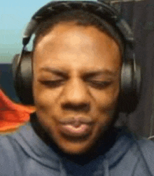 a close up of a man wearing headphones and making a face .
