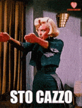 a woman is standing in front of a window with the words sto cazzo written on the bottom