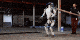 a man stands next to a robot that is holding a pipe