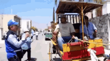 a man in a blue hat stands next to a man in a horse drawn carriage